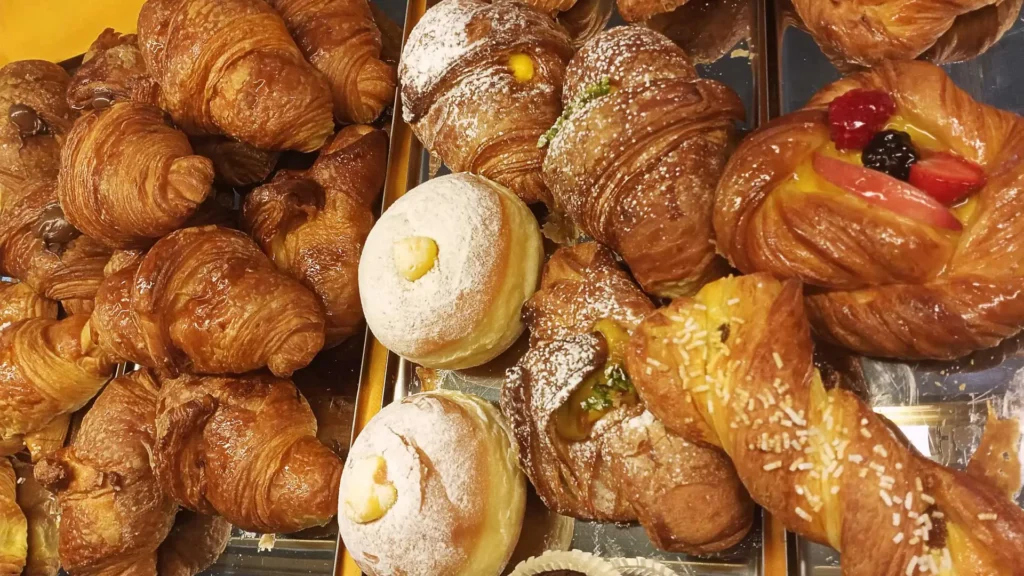 foto dall'alto di brioches e vaie sfiziosità che si possono trovare alla mattina presso il bar della forneria